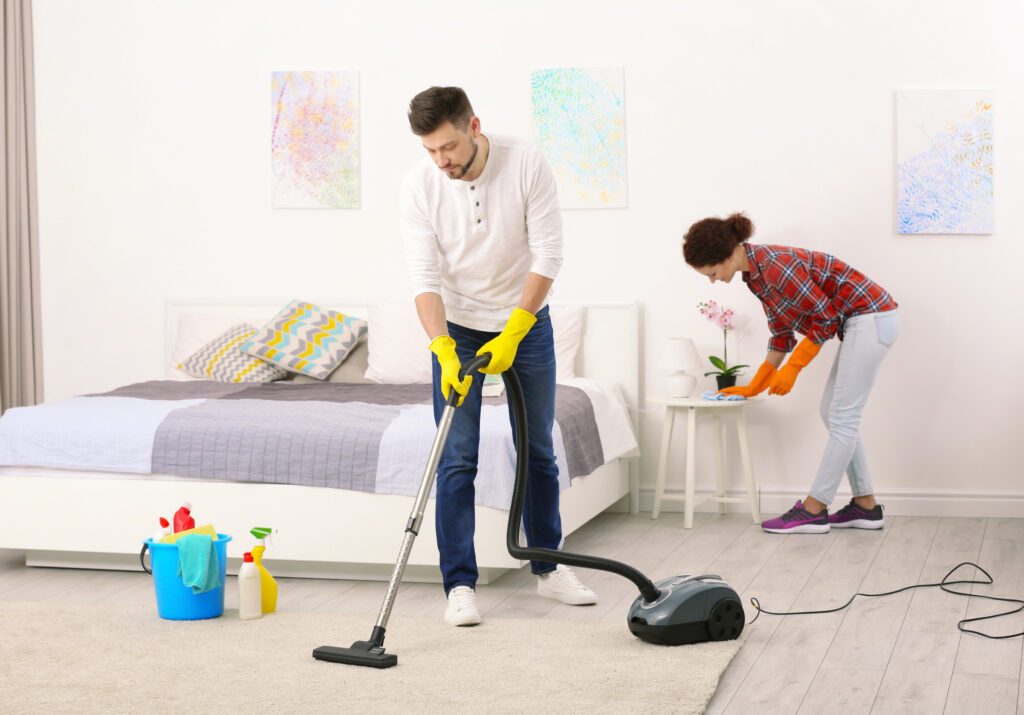 Happy young couple cleaning home together