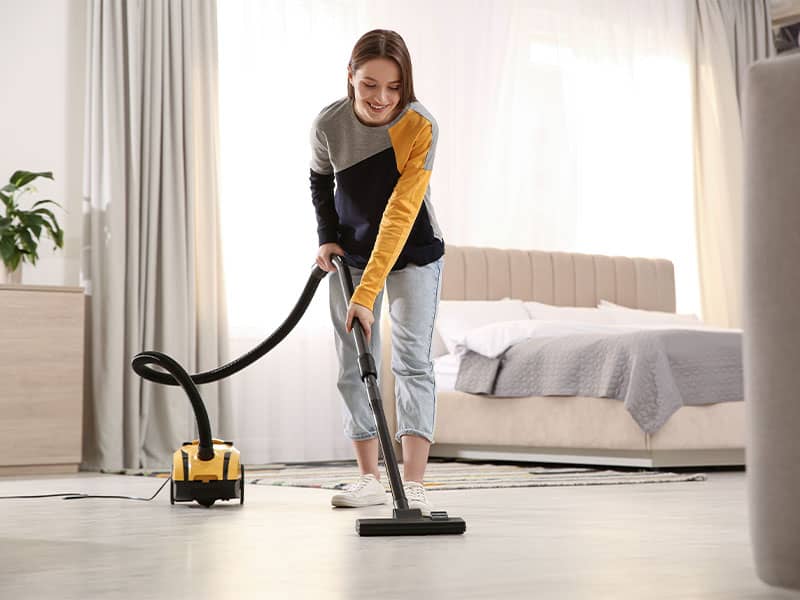 A woman vacuum the floor